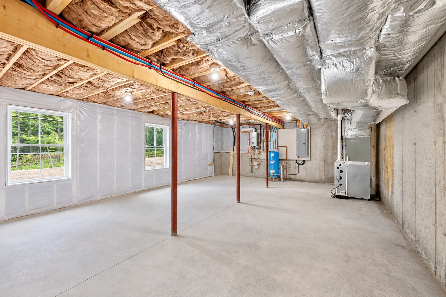 A finished basement shows insulated ceiling joists, silver HVAC ducts, plastic-covered walls, windows and utility equipment.